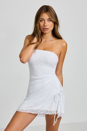 Model wears a white mini dress. 