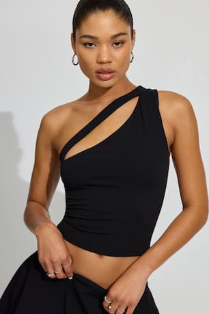 Model wears a black asymmetrical top with a cut out and a black skirt.